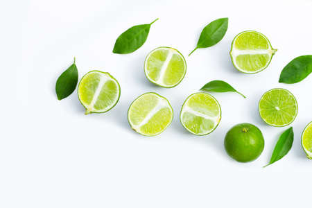 Fresh limes with green leaves on white background. Top view