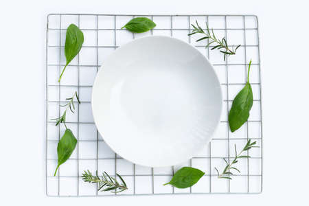 Empty plate with rosemary and basil leavesの写真素材