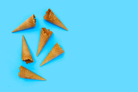 Empty ice cream cone on blue background.