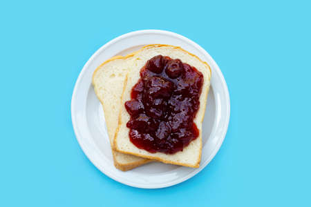 Bread with strawberry jam on blue backgroundの写真素材