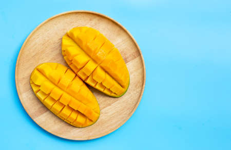 Tropical fruit, Mango in wooden plate on blue backgroundの写真素材