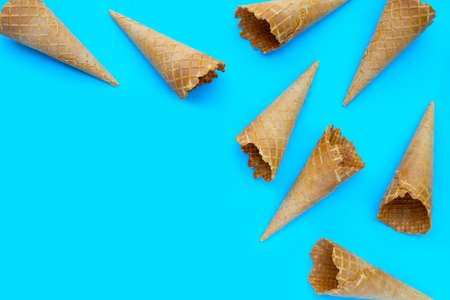 Empty ice cream cone on blue background.