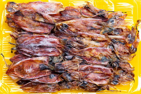 Dried squid on yellow background.の写真素材