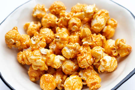 Honey caramel popcorn on white background.の写真素材