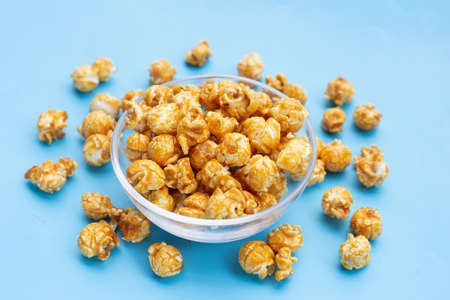 Honey caramel popcorn on blue background.の写真素材