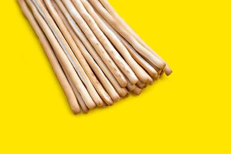 Bread sticks on yellow background
