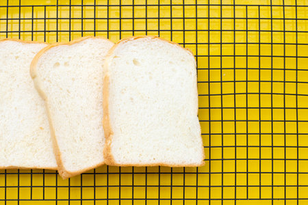 Sliced bread on yellow background.の写真素材
