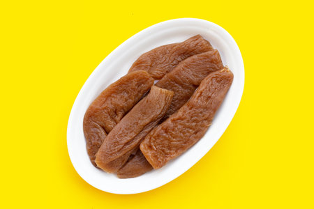 Preserved turnip (radish) in plate on yellow background.の写真素材