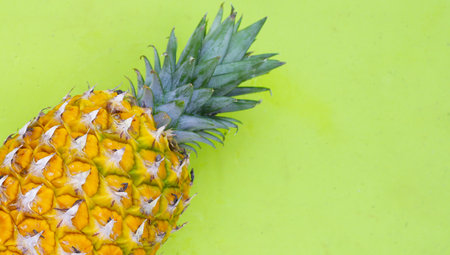 Fresh pineapple on green background.