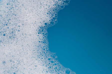 Detergent foam bubble on water. Blue background, Soap sudの写真素材