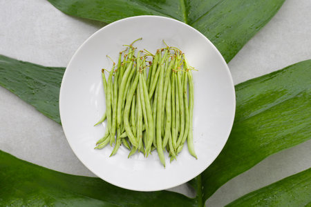 Fresh needle beans on white plate