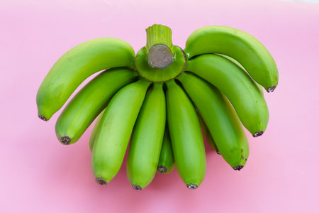 Green banana fruits on pink background.の写真素材