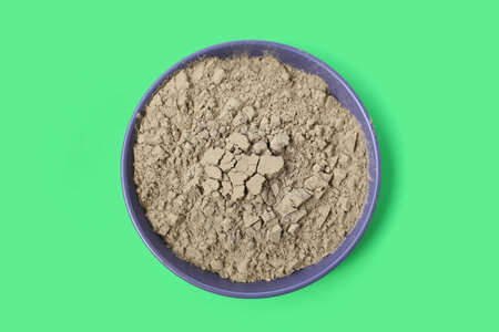 Powder in a wooden spoon on white background.