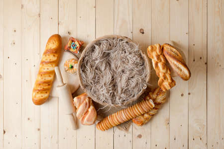 Basket covered with feathers on wood floor.の写真素材