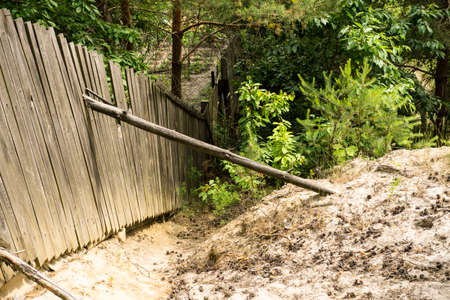 Wooden fence, backed by log and a pile of sandの写真素材