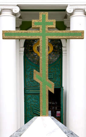Big green christian golden cross at entrance to templeの写真素材