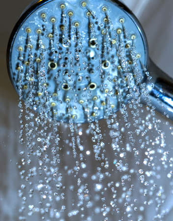 Water drops close-up dripping from the shower blue filteredの写真素材