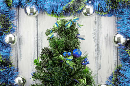 New year theme christmas tree with blue and green decoration and silver balls on white retro stylized wood backgroundの写真素材