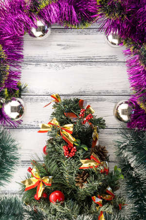 New year theme: christmas tree with pink and green decoration and silver balls on white retro stylized wood backgroundの写真素材