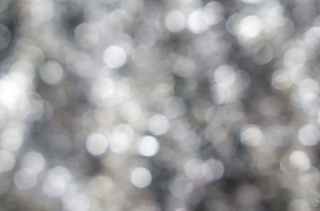 Abstract blured background of dark contrast silver white shiny Christmas tree decorationsの写真素材
