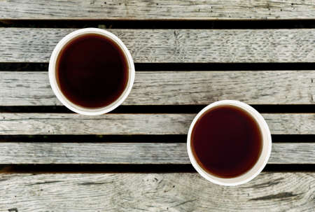 Couple of cups of tea on wooden surface warm filteredの写真素材