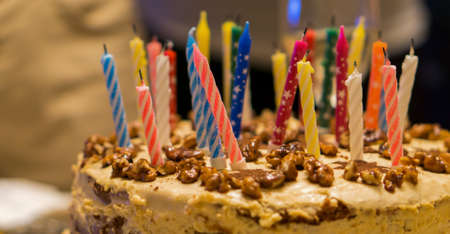 Birthday cake with nuts and candles backgroundの写真素材