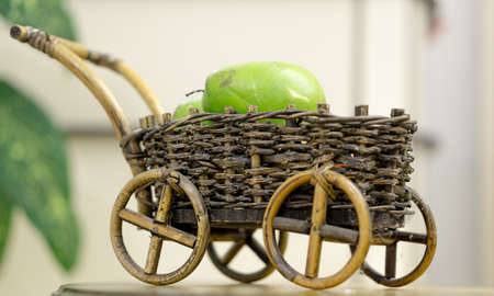 Wicker decorative cart with fruits on white backgroundの写真素材