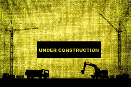 "Under construction" concept at building site with detailed silhouettes of construction machines on olive color cloth texture backgroundの写真素材