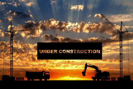 Under construction concept at building site with detailed silhouettes of construction machines on...