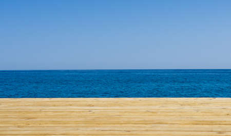 Wooden pier, sea and blue sky background. Holiday travel concept. Empty space for summer banner....