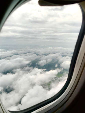 An aerial view which took by passenger on window seat shows agricultural landscape, river, road,...