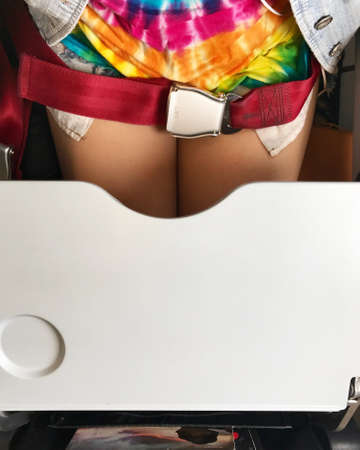 Airplane cabin is all white. All its decorations are necessary stuffs and safety. The gray Tray table for passenger in plane.の写真素材