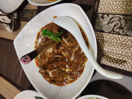 Traditional beef curry with rice in a white plate.