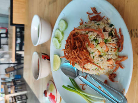 Thai style fried rice with shredded pork and vegetable on white dish