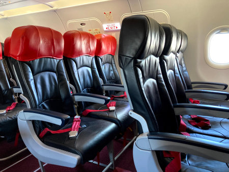 Inside of passenger aircraft cabin, single aisle, economy seat. Economy cabin. Airplane cabin and aisle with empty comfortable seats in economy class inside of plane.の写真素材