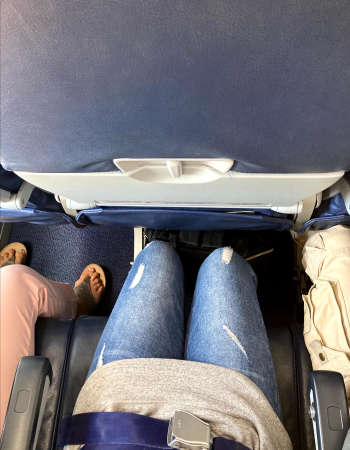 Rear view of a couple sitting on the back seat of an airplane