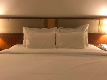 Interior of a hotel room with two white pillows on the bed