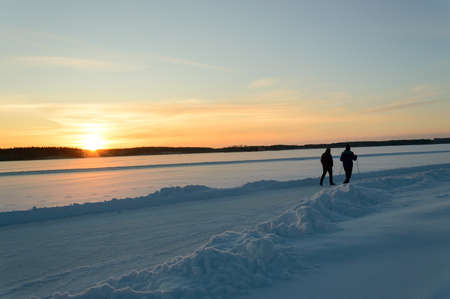 Hiking in scandinavia winter sunset on frozen lakeの写真素材