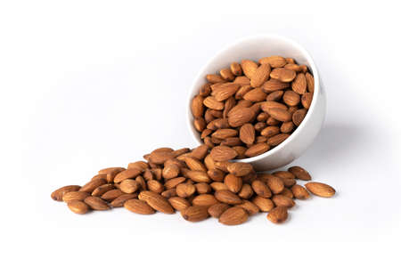 Almonds in a white bowl on a white background