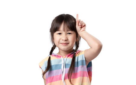 Portrait of Asian beautiful young girl pointing up one hand with finger on upper side with smile...
