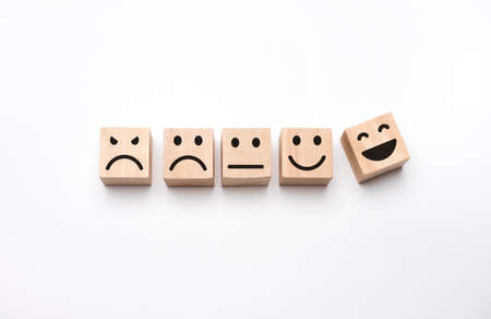 Square shaped wood with faces in a variety of moods. Customer service evaluation and satisfaction survey concepts.の写真素材