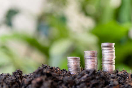 pile of silver coins with green nature background. money saving and business finance concept,...