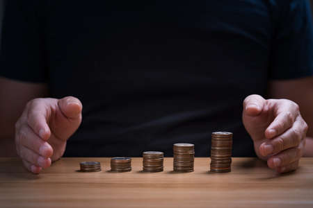 businessman protecting money, financial stability management concept. Savings and pensions, collecting money, financial planningの写真素材