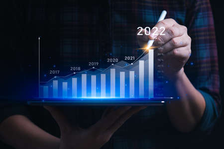 Business growth and progress concept. Businessman is showing virtual hologram chart from tablet. plans to increase business growth and an increase in the indicators of positive growth in 2022の写真素材