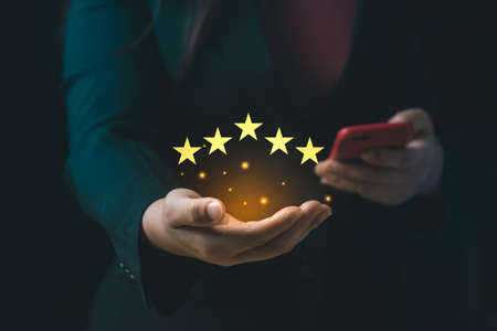 Customer satisfaction concept. Hand with thumb up Positive emotion smiley face icon and five star with copy space. 5 star satisfaction, Excellent business rating experienceの写真素材