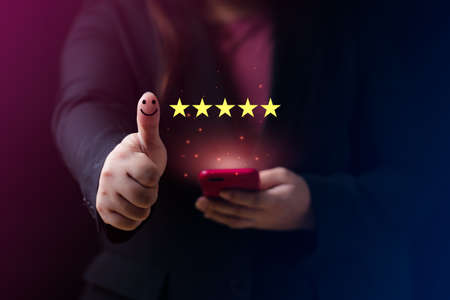 Customer satisfaction concept. Hand with thumb up Positive emotion smiley face icon and five star with copy space. 5 star satisfaction, Excellent business rating experienceの写真素材