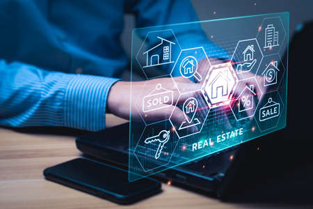 real estate concept, Businessman or home broker with virtual hologram property value on laptop screen. Searching and investing in real estate buy a new home for the family, home search, property taxの写真素材