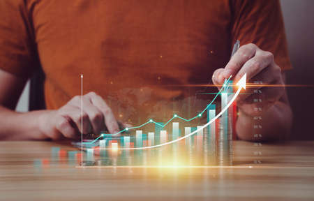 Businessmen plan and calculate business finances for future growth with virtual holographic charts and arrows. Return on Stocks. business strategy. Development to success and motivation. exchangeの写真素材