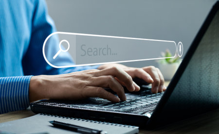 Businessman hand using laptop or computer to search information on internet social media web with search box icon and copy space. search engine information search technologyの写真素材
