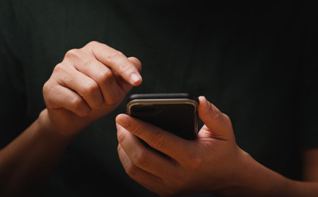 man's hand using a mobile phone browsing mobile device apps, reading news, chatting or shopping...